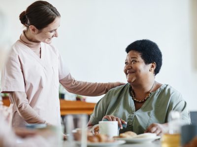 caring young woman working in nursing home